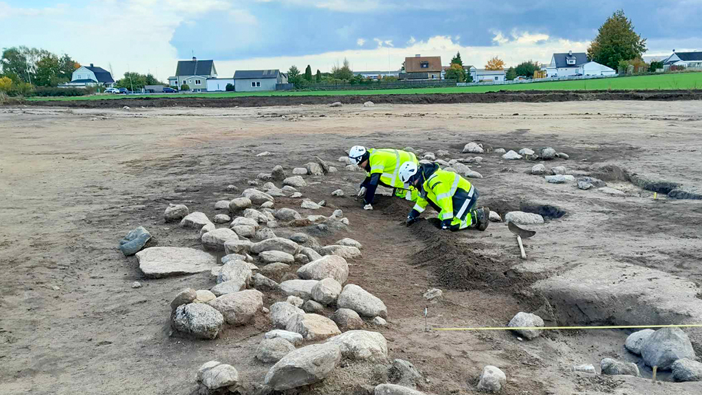 Arkeologer gräver den stensatta kanten vid våtmarken. Foto: Arkeologerna