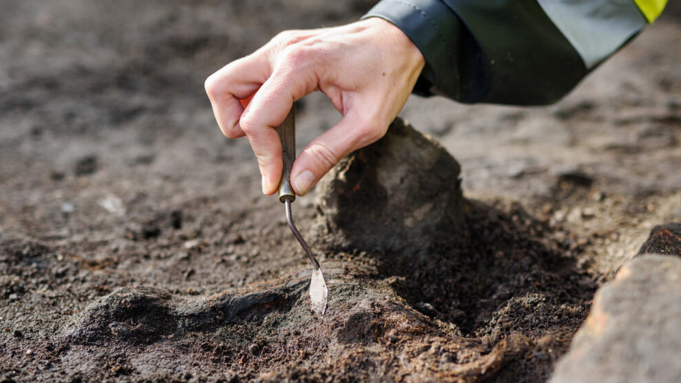 En arkeologs hand vid utgrävning. Foto: Markus Andersson (CC-BY)